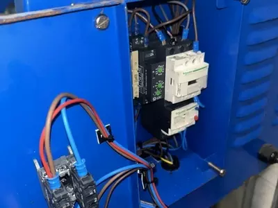 Failed electrical contactor inside the control panel of a Nilfisk DTE wall-mounted static pressure washer before replacement.